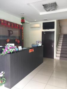 a lobby of a restaurant with a counter and stairs at Premierz Hotel in Labuan