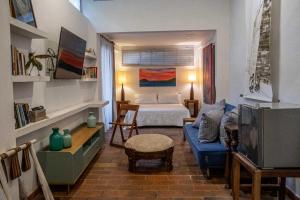 a living room with a bed and a blue couch at Casa De Columnas in Cartagena de Indias