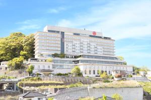 a large white building with a red sign on it at Ooedo Onsen Monogatari Premium Nagasaki Hotel Seifu in Nagasaki +10 photos