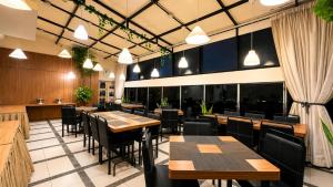 a restaurant with wooden tables and chairs and windows at Vio Veteran in Bandung