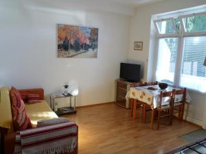 uma sala de estar com uma mesa e uma televisão em Apartments Villa Kosovic - ground floor em Dubrovnik