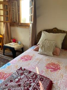 a bedroom with a bed with a bedspread with roses at El Rabwa Rooms in Alexandria