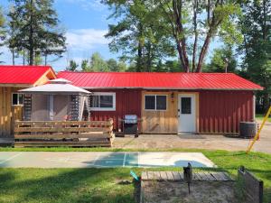 a red shed with a red roof and a basketball court at Pine Ridge Park Campground in Pembroke +26 photos