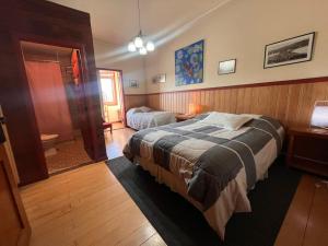 a bedroom with a bed and a bathroom at Amura Hostel in Puerto Varas