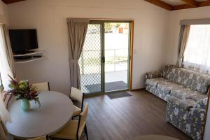 a living room with a table and a couch at Beaufort Lake Caravan Park in Beaufort
