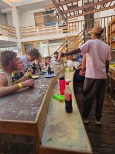 a group of people sitting around a long table at Shambala Hostel in Huacachina +18 photos