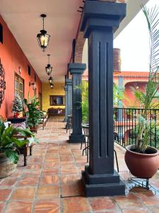 a hallway with columns and tables and plants in a building at Casa Punta Perula VILLAS in Pérula