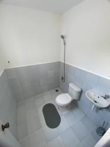 a white bathroom with a toilet and a sink at Home Vacation in Ormoc City in Catmon