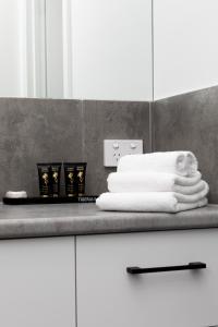 a pile of towels on a counter in a bathroom at The Lime Loft, Rooftop Views in Mildura's CBD in Mildura +34 photos