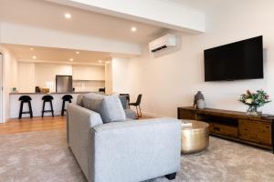 a living room with a couch and a flat screen tv at The Lime Loft, Rooftop Views in Mildura's CBD in Mildura