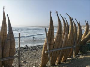 a group of straw umbrellas on a beach at Hospedaje restaurant Sr de Sipan in Sipán