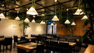 a dining room with tables and chairs and lights at Vio Cihampelas in Bandung