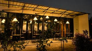 a restaurant with tables and chairs at night at Vio Cihampelas in Bandung