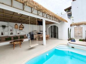 a villa with a swimming pool and a house at Villa Nala Uluwatu by LODGELINK BALI in Uluwatu