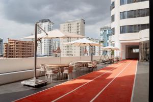a rooftop deck with tables and umbrellas on a building at Le Conde Maison in Phnom Penh