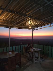 two people sitting at tables on the top of a mountain at Senaru sunset house in Senaru