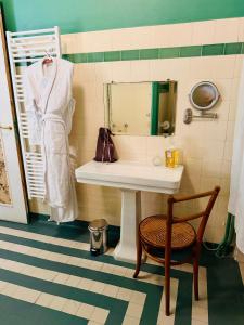 a bathroom with a sink and a chair and a mirror at La Maison au toit vert in Espalion +92 photos