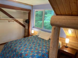 a bedroom with a bed and a large window at Beach Roadhouse in Haines