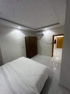 a bedroom with a large white bed in a room at شقة غرفة وصالة in Musaylah