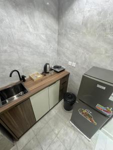 a small kitchen with a sink and a refrigerator at شقة غرفة وصالة in Musaylah