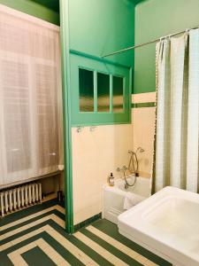 a bathroom with a tub and a sink and a shower at La Maison au toit vert in Espalion