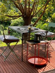 a table and chairs on a deck with a tree at 春まち in Ito