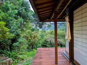 a porch of a house with a wooden walkway at 春まち in Ito