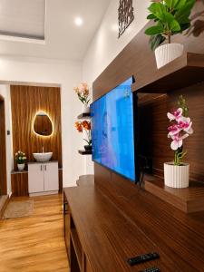 a living room with a large flat screen tv at Birdwing Cottage, Munnar in Munnar