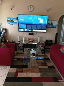 a living room with a large television and a table at Fano's Oasis in Castries