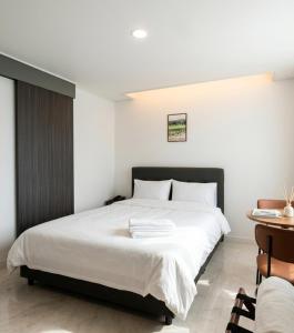 a bedroom with a large white bed and a desk at 스테이큐브 505 in Chŏnju-yŏk