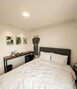 a bedroom with a large white bed and a desk at 스테이큐브 505 in Chŏnju-yŏk