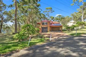 a house with a garage on the side of a road at Sunset Nest No 1 in Sanctuary Point