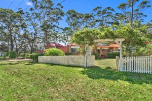 a fence in a yard with a house in the background at Sunset Nest No 1 in Sanctuary Point +10 photos