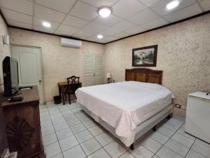 a bedroom with a bed and a desk and a television at Hotel La Estacion in La Unión +17 photos