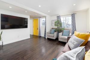 a living room with a couch and a flat screen tv at Executive Stay Inn free parking in Oakland