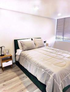 a bedroom with a large bed and a night stand at Faro 4, Jaime Duque, Autódromo Tocancipá in Tocancipá