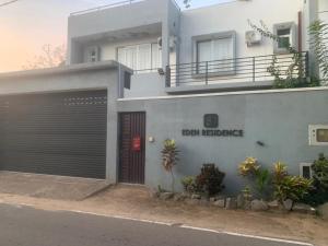 a building with a garage with a sign that reads dean residence at Airport Transit Home in Ja-Ela