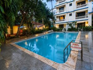 a swimming pool with a sign in front of a building at Goan Casa Feliz in Calangute
