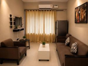 a living room with a couch and a table at Goan Casa Feliz in Calangute