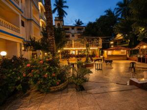 a courtyard with tables and chairs and flowers at night at Goan Casa Feliz in Calangute