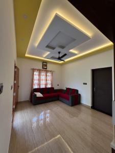a living room with a couch and a ceiling at Kurishingal Guest House in Mararikulam
