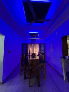 a purple room with a dining room table and chairs at Kurishingal Guest House in Mararikulam
