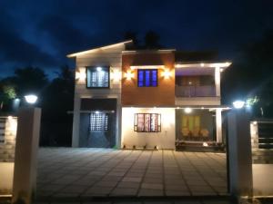 a house with lights on the front of it at night at Kurishingal Guest House in Mararikulam