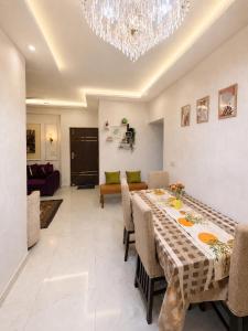 a dining room with a table and a chandelier at Riwaayat & Wings, a luxe stay 5 min from Taj Mahal in Tājganj