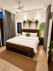 a bedroom with a large bed with white sheets at Riwaayat & Wings, a luxe stay 5 min from Taj Mahal in Tājganj +10 photos