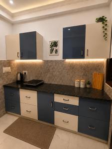 a kitchen with a black and white counter top at Riwaayat & Wings, a luxe stay 5 min from Taj Mahal in Tājganj