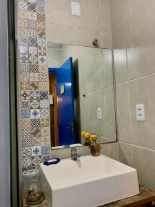 a bathroom with a white sink and a mirror at Casa de Campo in Guaíba