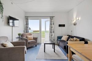 a living room with a couch and a table at Sct Knudsborg - 12E - Apartment on the beach in Brenderup