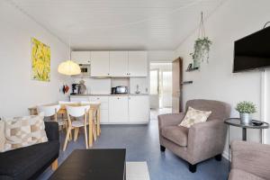 a living room with a couch and a table and a kitchen at Sct Knudsborg - 12E - Apartment on the beach in Brenderup