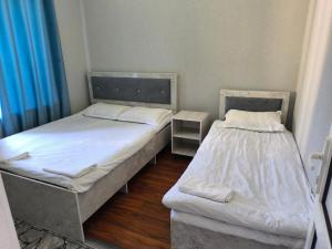 two beds in a small room with blue curtains at Амир in Arkit